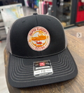 Black and gray cap with a logo on a wooden surface